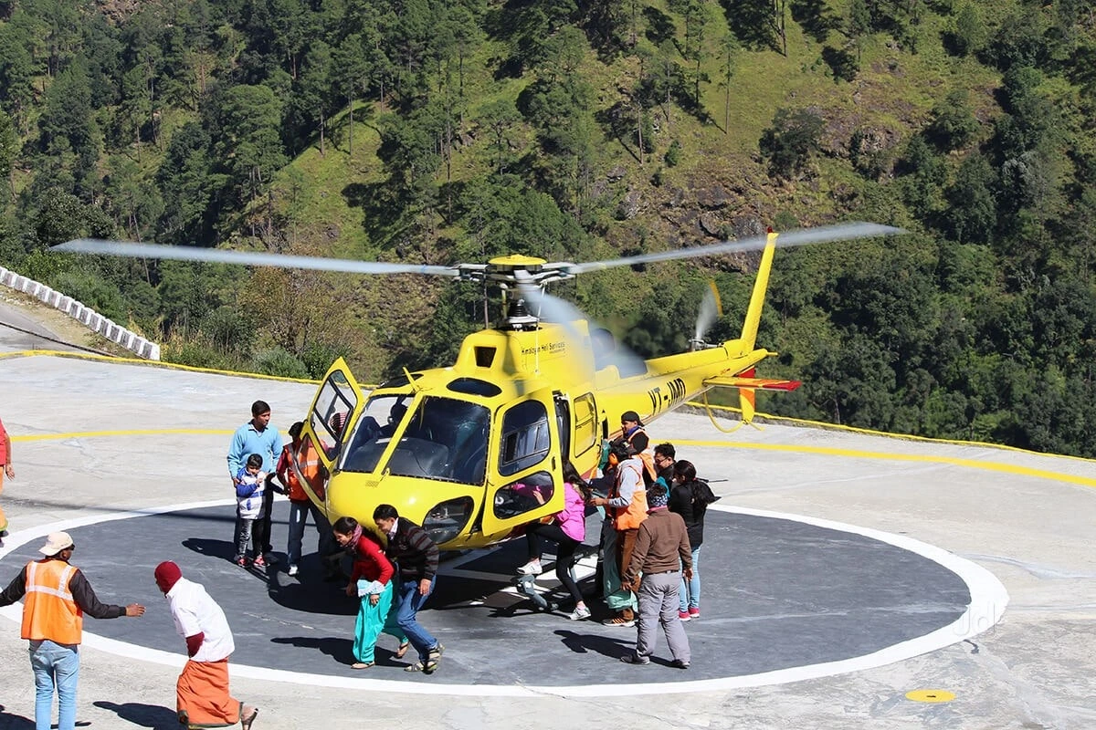 Pilgrims boarding a helicopter for Amarnath Yatra at a helipad surrounded by scenic mountains. Amarnath helicopter booking offers a quick and comfortable journey to the holy cave.