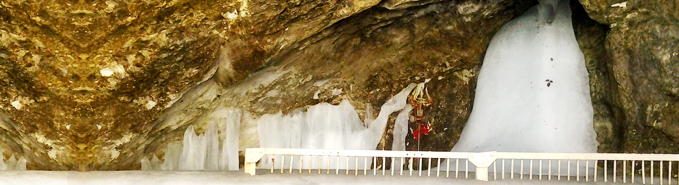 Sacred Amarnath Cave with the naturally formed ice Shiva Lingam, a revered Hindu pilgrimage site in Jammu and Kashmir, accessible via Amarnath helicopter booking.